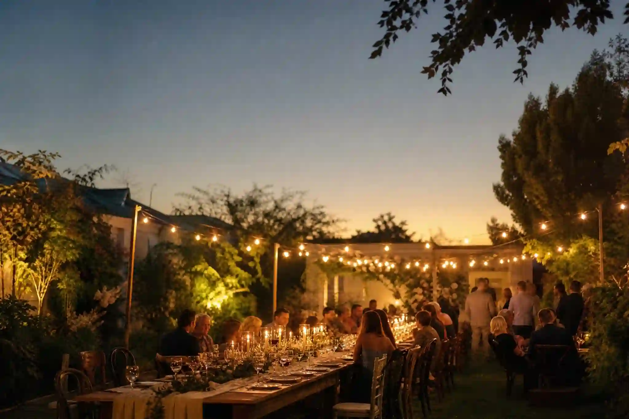 small backyard wedding ideas with string lights and long table,cozy small backyard wedding ideas with mismatched chairs and florals,budget-friendly small backyard wedding ideas table setup